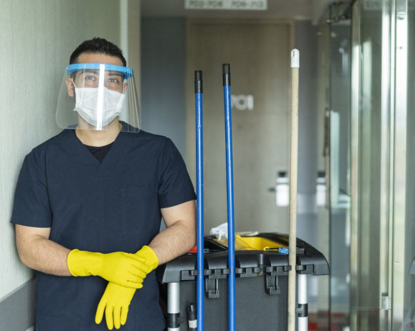 A Man of Latino ethnicity aged between 20-30 years is doing cleaning work in a building in times of pandemic due to the COVID-19 quarantine