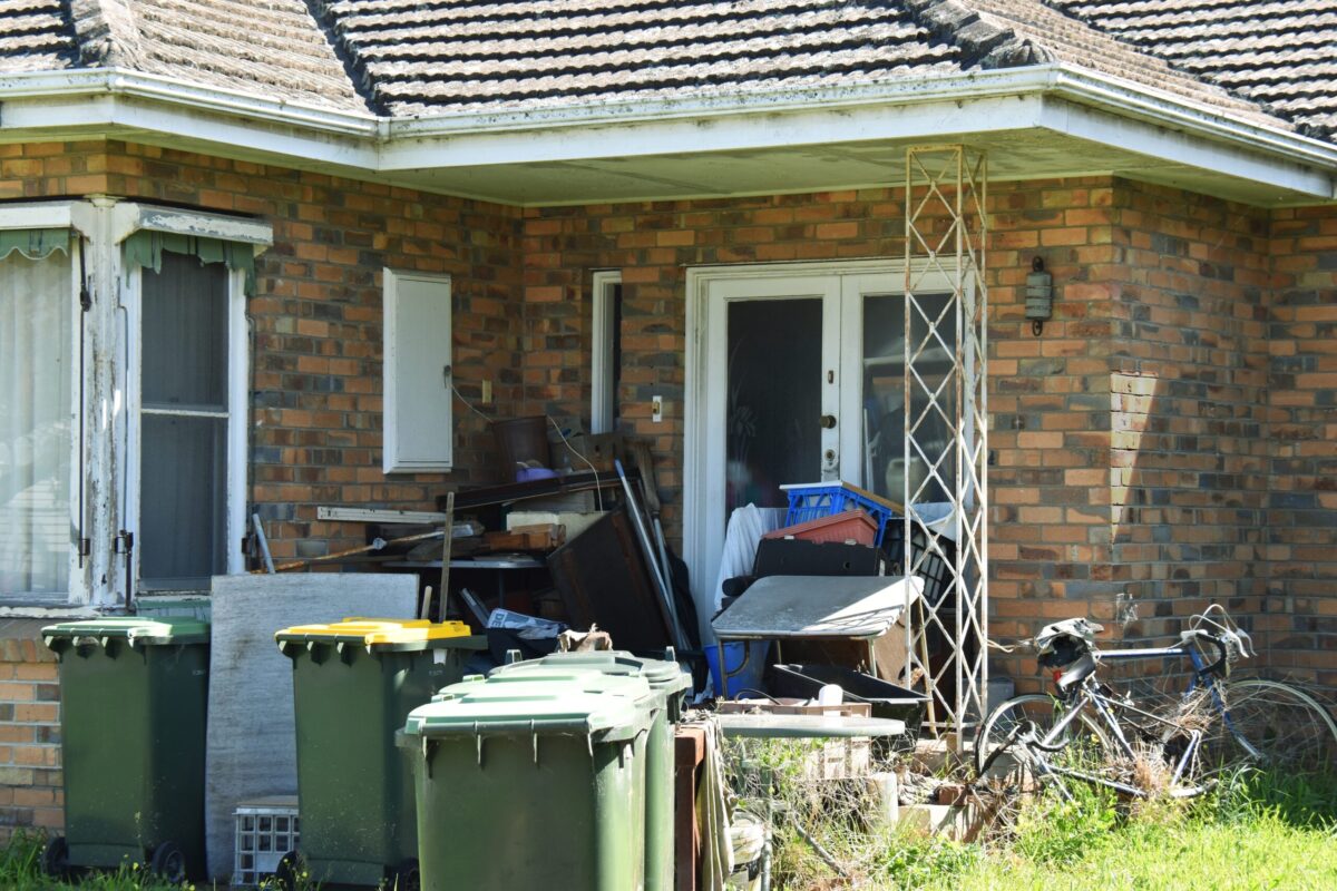 front porch covered with trash, hoarding